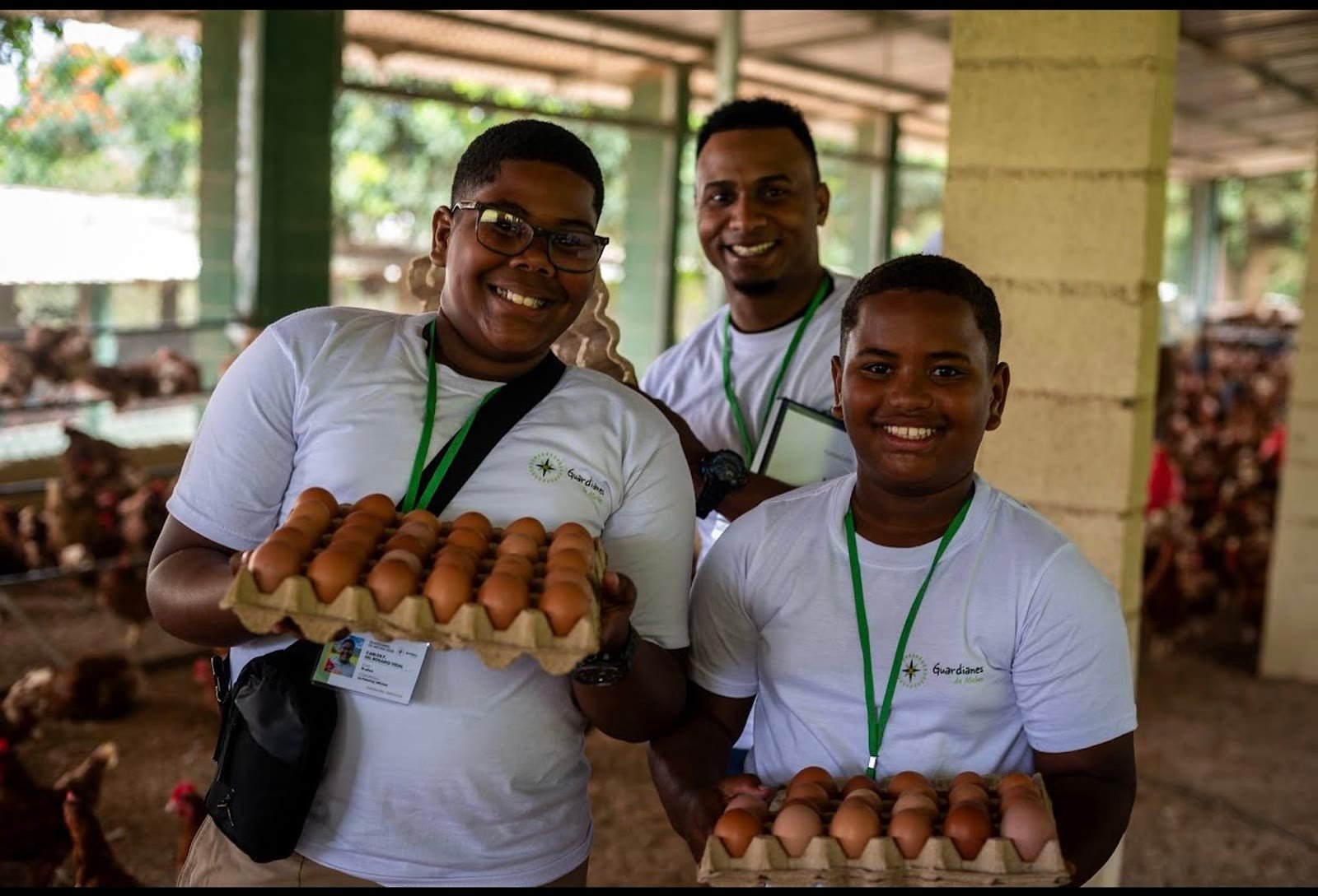 Niños del programa educativo Guardianes de Miches visitando la finca con cartones de huevos